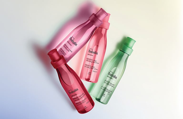 Imagen con frascos de productos en tonos rosa, verde, rojo y morado sobre un fondo suave. Los frascos están dispuestos de manera atractiva.